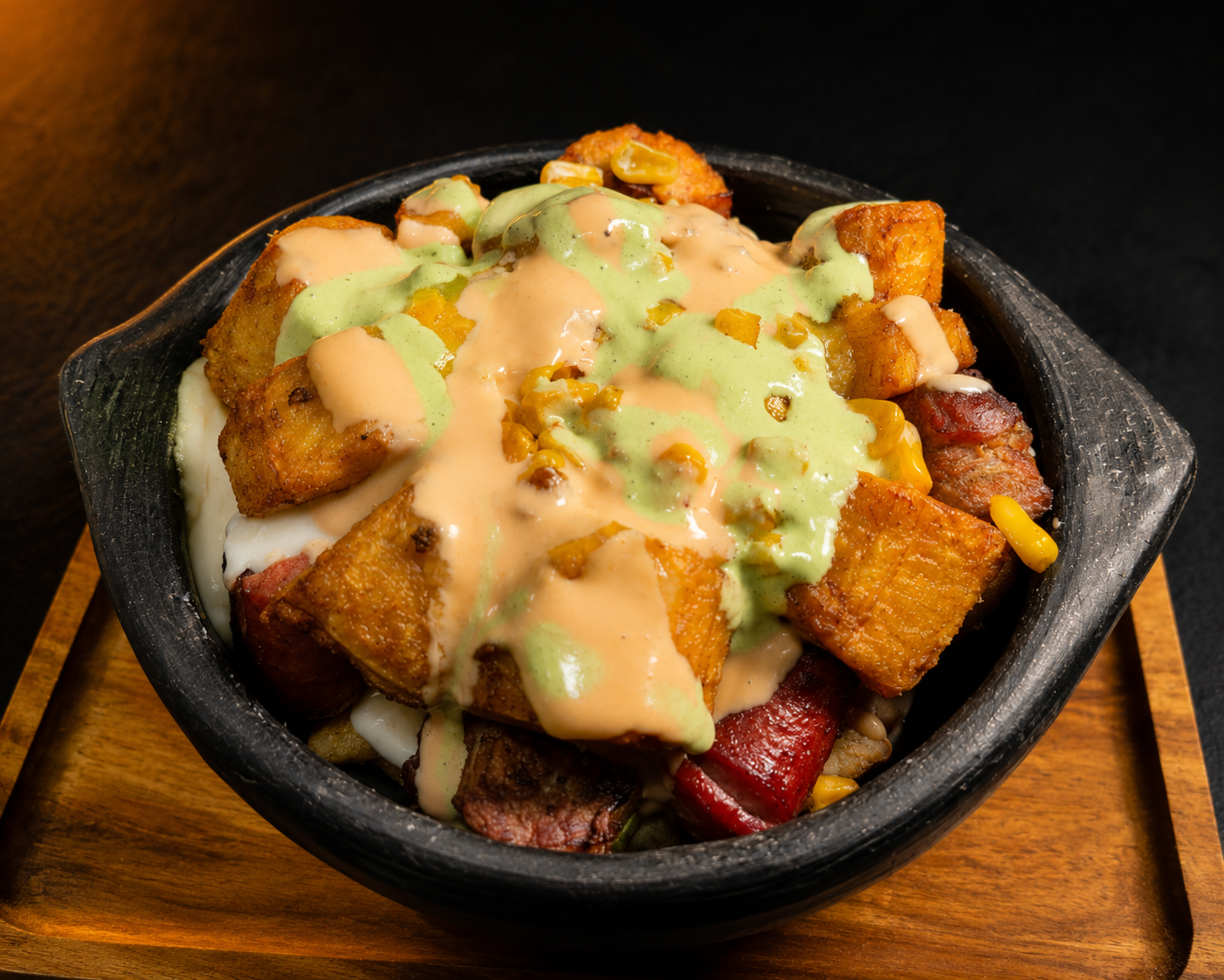 Salchipapa ¡Qué Chimba! — loaded fries with sausage, steak, corn and house sauces in a black bowl